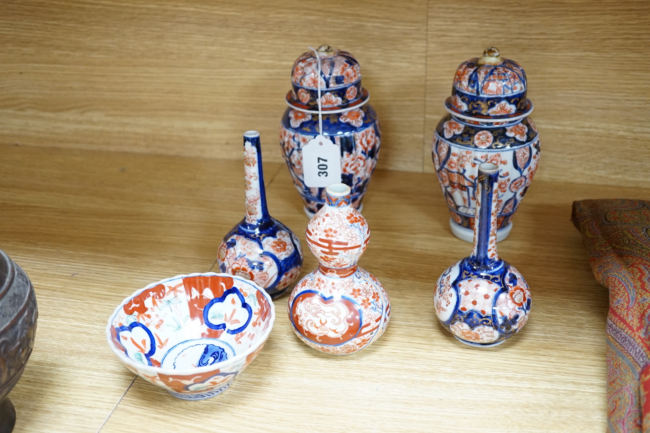 Nine Japanese Imari pieces including; a charger, lidded pot, a bowl, four small gourd vases, two lidded vases and a teapot (a.f.), charger 31cm diameter